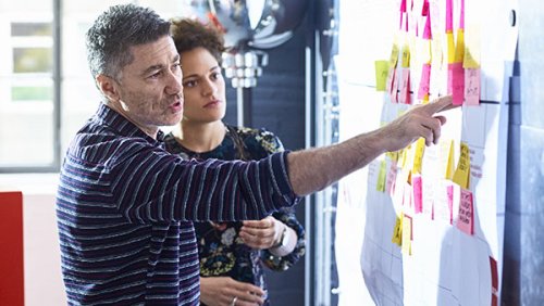 Woman and man looking at an agile board with sticky notes