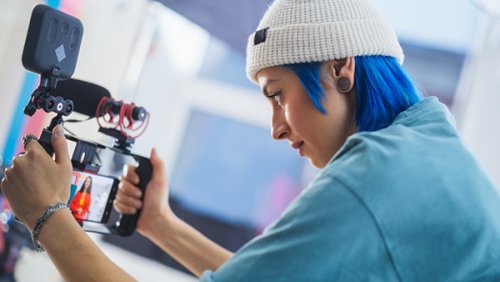 Woman with blue hair working on video production